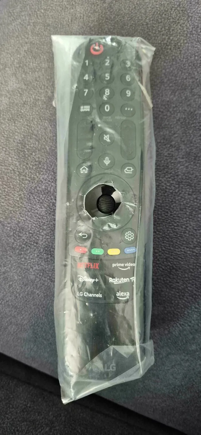 Mando de televisión envuelto en plástico protector con un agujero roto en el centro por una de las esposas.
