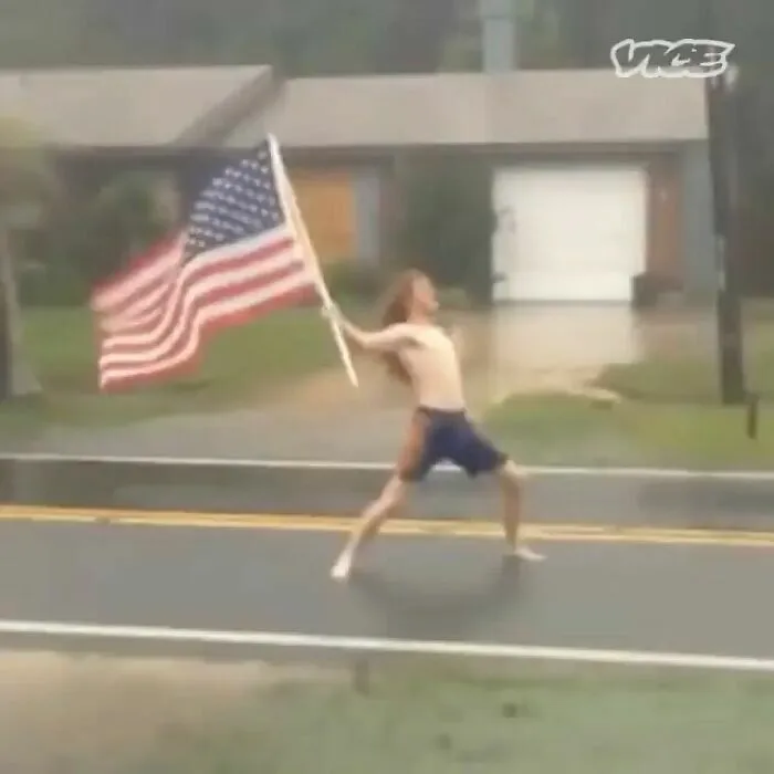 Hombre sin camisa con bandera de EE. UU. en la tormenta, reflejando memes de Florida.