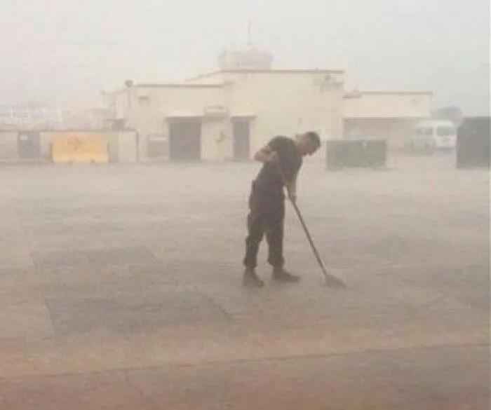 Soldado barriendo el suelo durante una tormenta de arena, personas que solo tenían 1 cosa que hacer.