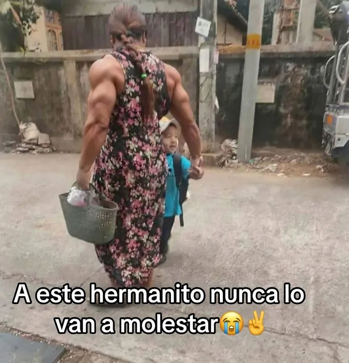 Una de las publicaciones que causan risa de una madre con grandes músculos llevando a su hijo de la mano