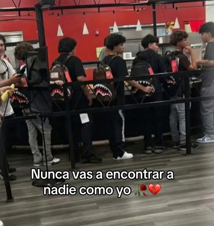 Fila de jóvenes idénticos con mochilas iguales que causa risa y vergüenza ajena