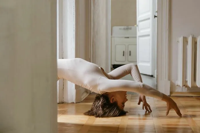 Mujer flexible haciendo poses artísticas en el suelo simulando ser gemelos
