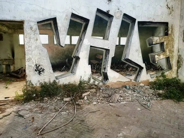 Grafiti en pared con estilo 3D en edificio abandonado con escombros