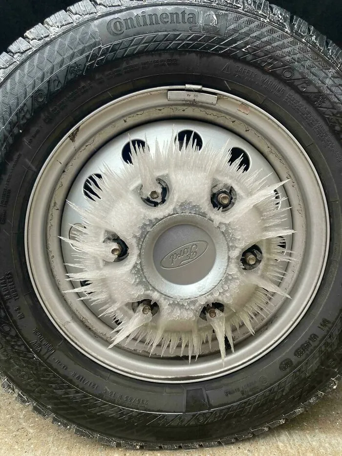 Rueda de automóvil con cristales de hielo formados en los tornillos