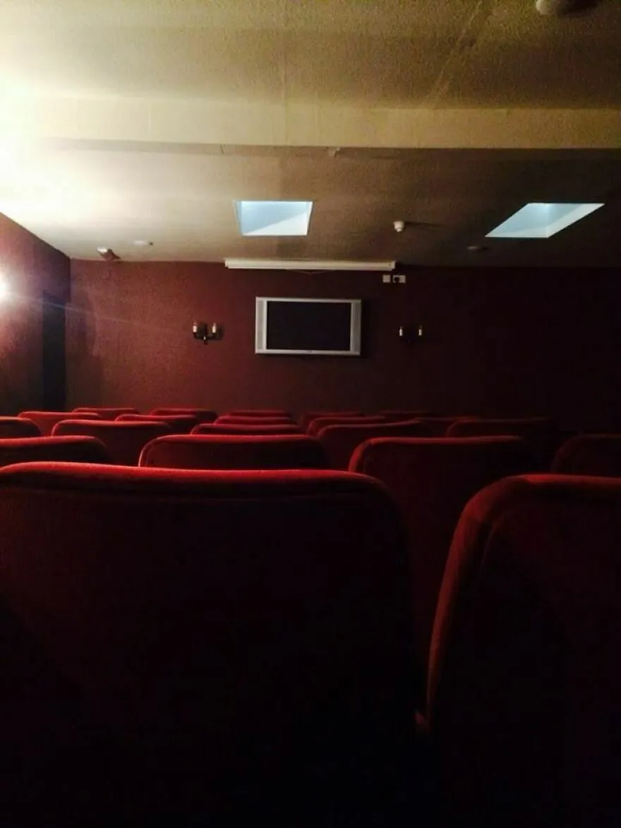 Sala de cine oscura con iluminación deficiente en hotel Airbnb