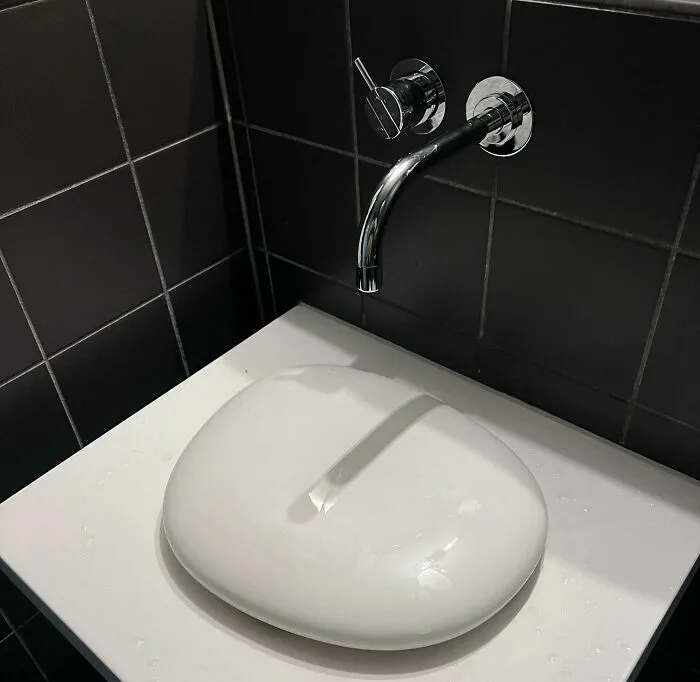 Lavabo moderno con diseño confuso que impide uso correcto del grifo en fallos de diseño divertidos