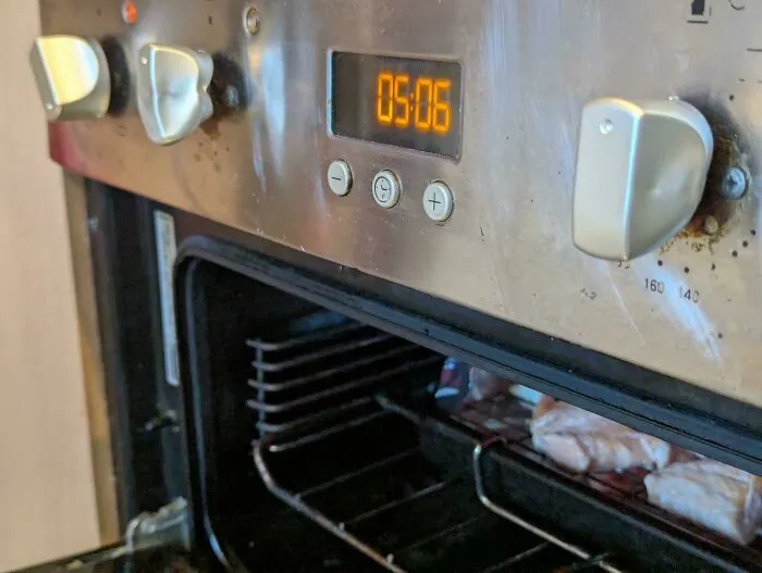 Horno con botón agrietado y óxido visible, ejemplo de fallo de diseño
