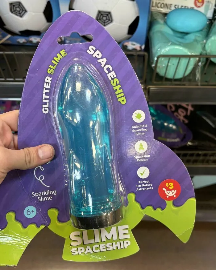 Juguete de slime con diseño de nave espacial azul en empaque púrpura y verde