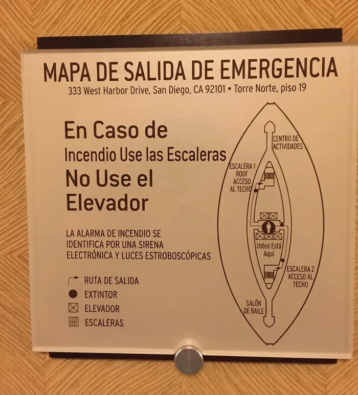 Cartel de mapa de emergencia confuso en la pared, mostrando fallos de construcción.