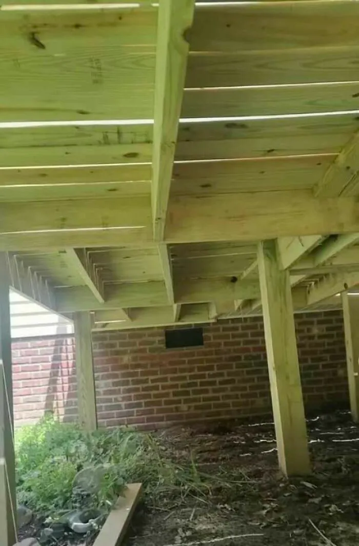 Estructura de madera mal apoyada en ladrillos, un claro ejemplo de fallos de construcción.