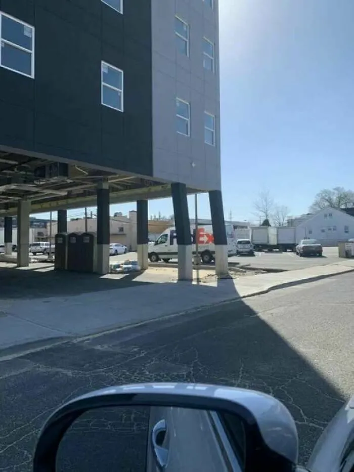 Edificio moderno sostenido por columnas inclinadas que muestran preocupantes fallos de construcción.