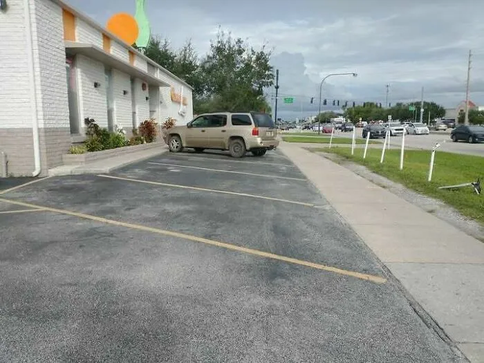 Líneas de estacionamiento mal pintadas en la acera, un absurdo fallo de construcción.
