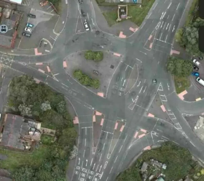 Vista aérea de una intersección vial caótica con marcas confusas, un claro ejemplo de fallos de construcción.