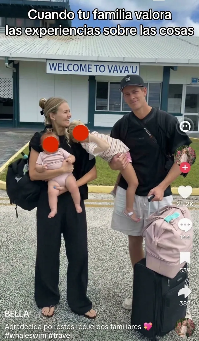 Familia de influencers haciendo el ridículo al posar cargando a sus hijos y maletas en un aeropuerto.