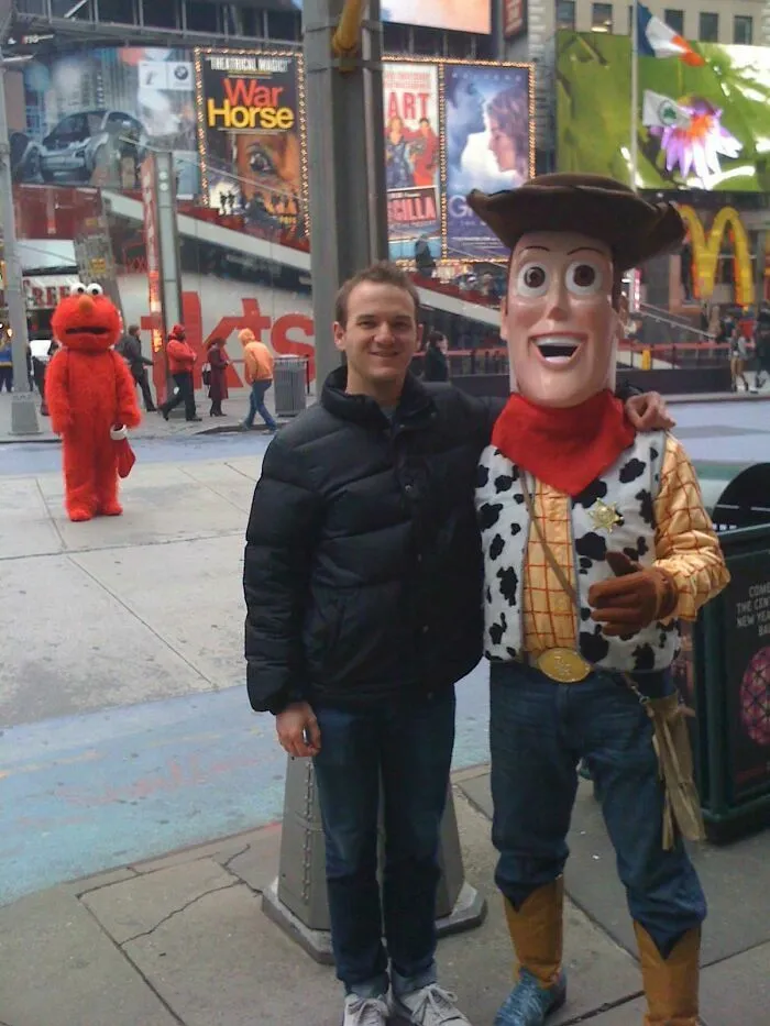 Un hombre junto a Woody en Times Square mientras Elmo camina al fondo en una de estas divertidas fotos.