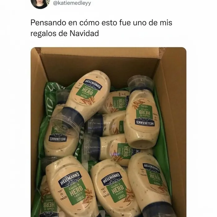 Una caja llena de botes de salsa de ajo y hierbas, ilustrando memes británicos sobre regalos de Navidad.