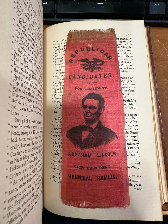 Marcapáginas de tela de Abraham Lincoln como ejemplo de objetos efímeros históricos dentro de un libro.