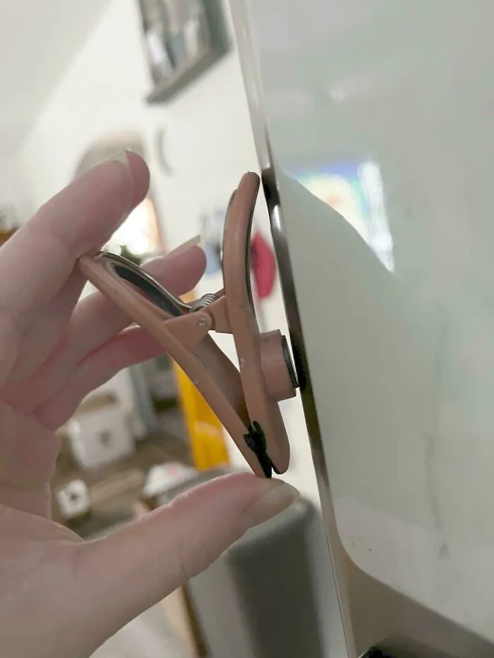 Pinza sujetando un espejo en un claro ejemplo de fallos de diseño.