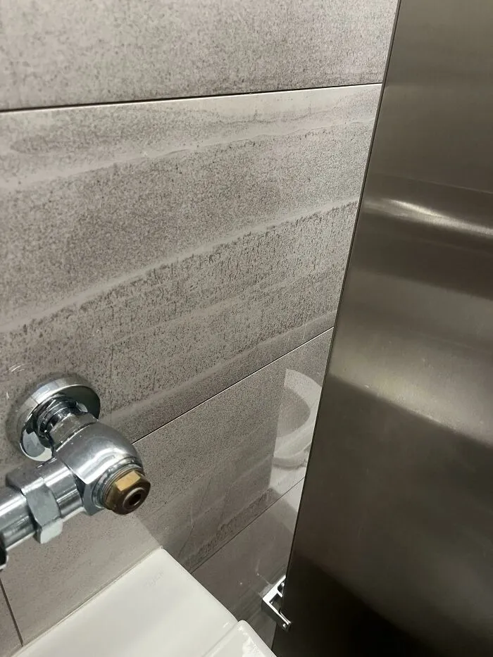 Ejemplo de fallos de diseño con una tubería instalada demasiado cerca de la pared del baño.