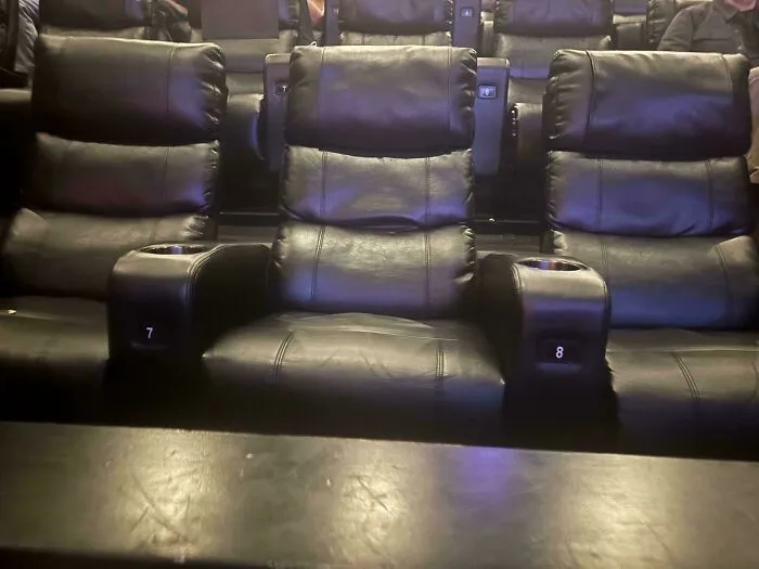 Butacas de cine mal alineadas respecto a los apoyabrazos, muestra de un fallo de diseño.