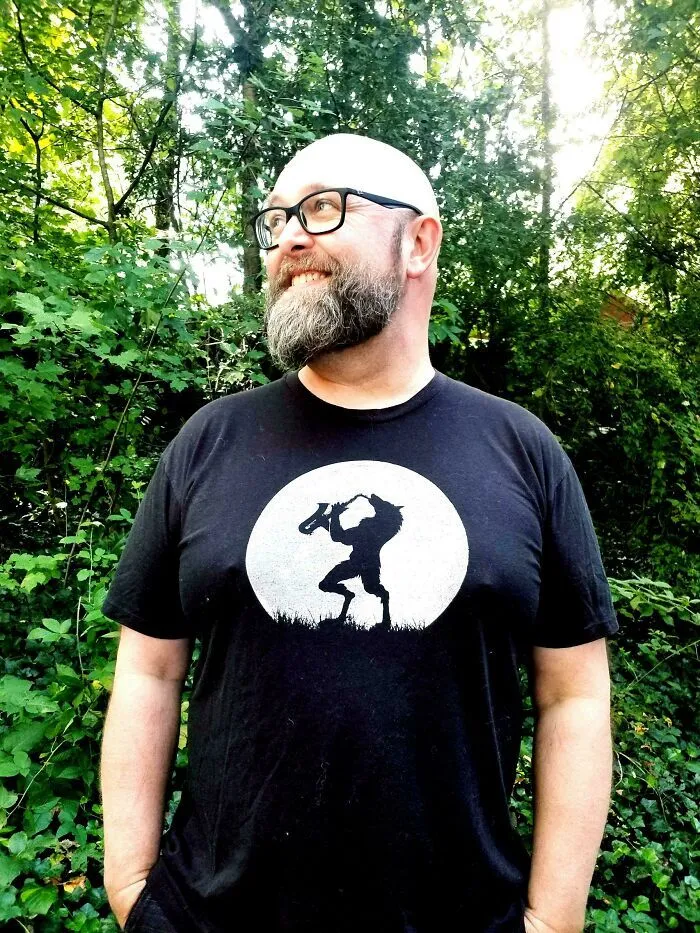Hombre sonriendo con camiseta divertida, ejemplo de publicaciones reconfortantes y alegres