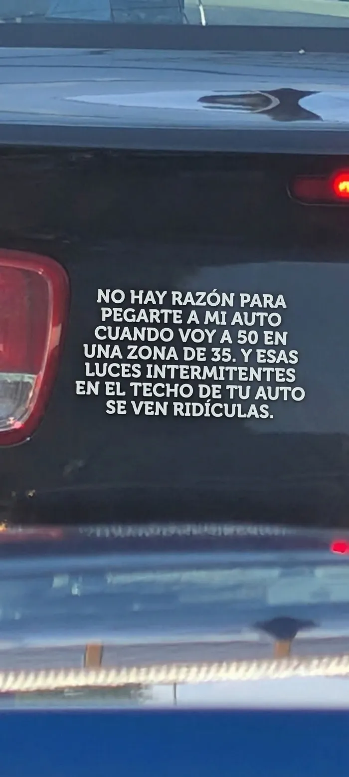 Coche negro mostrando un mensaje gracioso con pegatinas en los parachoques de los coches para la policía.