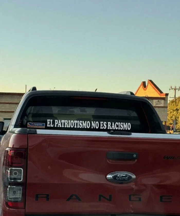 Pegatina con mensaje llamativo en la ventana trasera de una camioneta Ford.