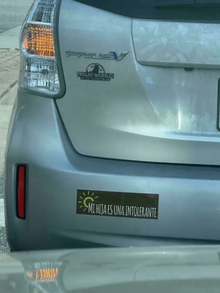 Pegatina divertida en el parachoques de un coche Prius con una frase curiosa.