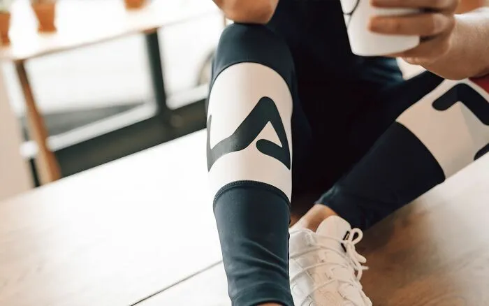 Detalle de una persona descansando en ropa deportiva en un entorno laboral tras ser despedida.