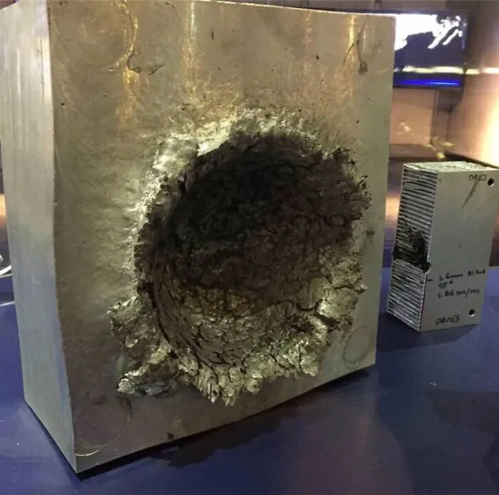 Bloque de metal impactado como metáfora de mentiras ridículas en internet.