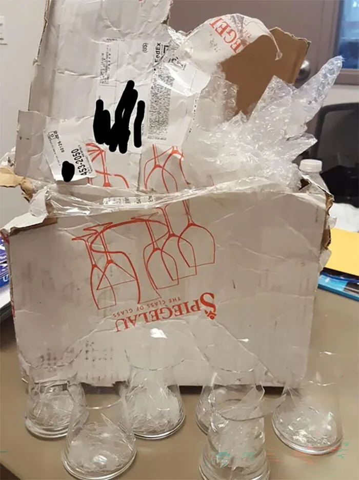 Caja de cartón destruida con copas rotas debido a malas entregas de repartidores