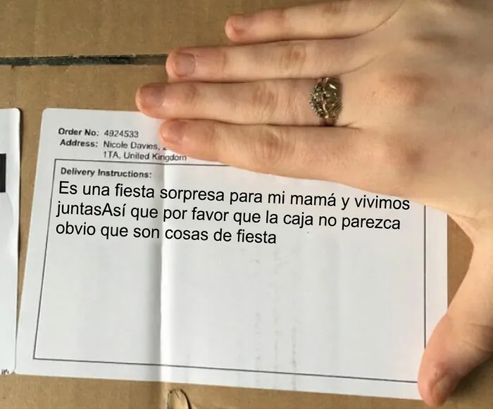 Mano sosteniendo la etiqueta de un paquete de repartidores con instrucciones.