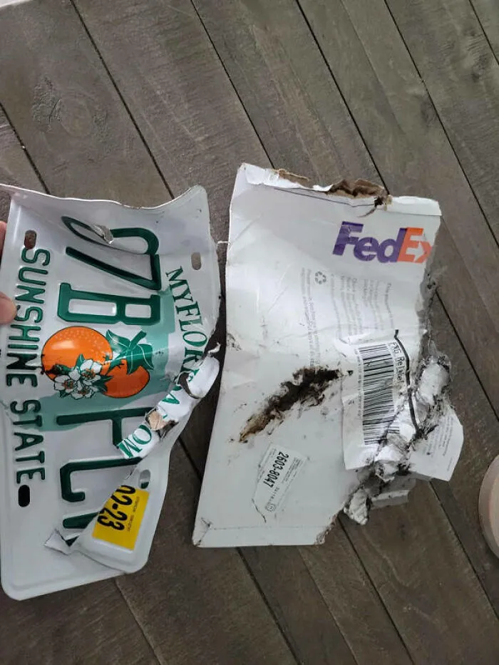 Placa de auto doblada y sobre roto entregados por repartidores.