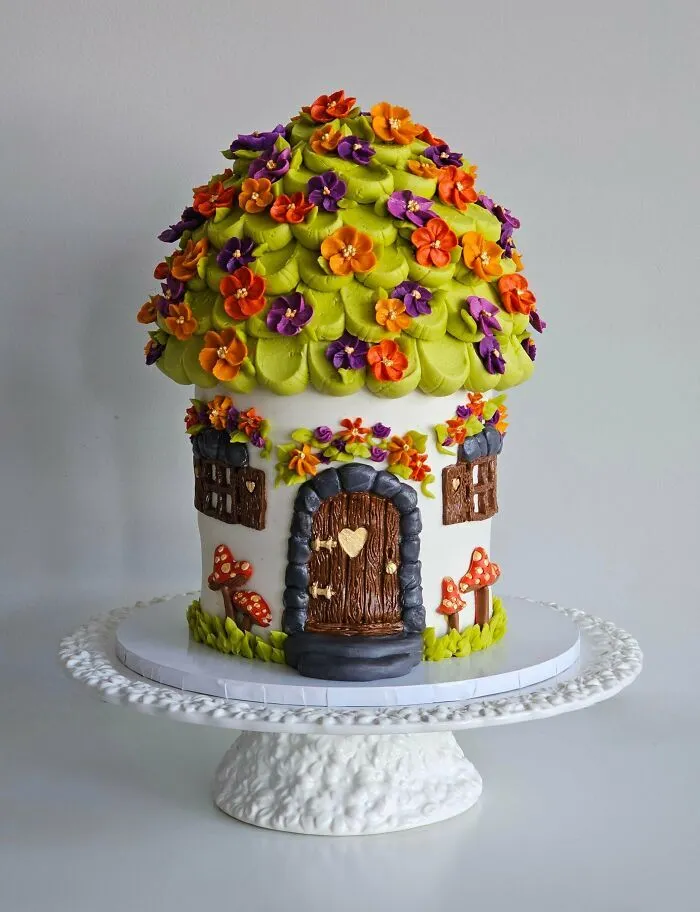 Tarta decorada como una casita de hongo fantástica de alta repostería.